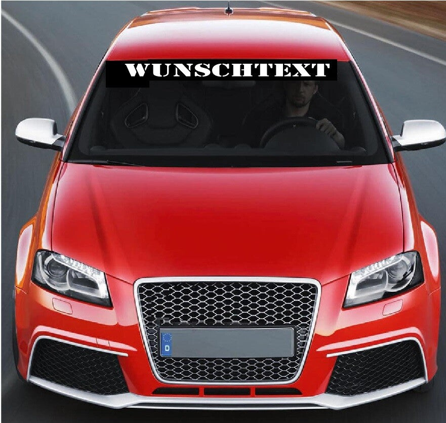 Wunschtext-Aufkleber oben auf der Windschutzscheibe eines roten Autos